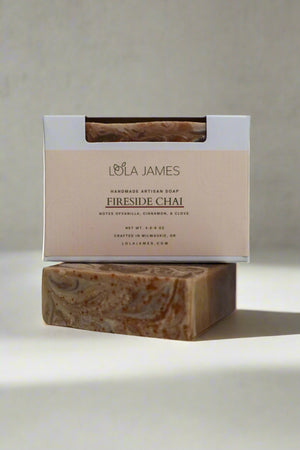 Brown and cream swirled soap stacked in packaging, gray background.