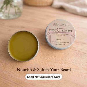 Two tins of Lola James Tuscan Grove beard balm on a wooden surface with promotional text.