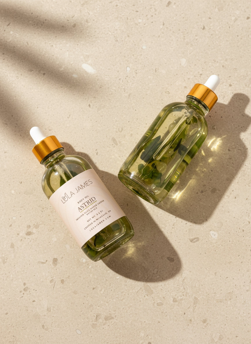 Two glass bottles with gold caps on a beige background