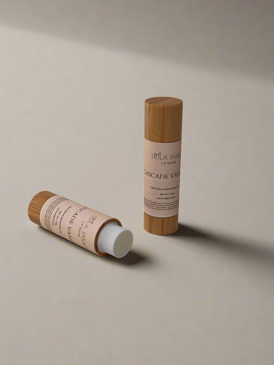 2 lip balms in bamboo containers on a  beige background.