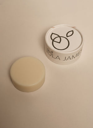 Cosmetic container with a white lid and beige base on a beige background