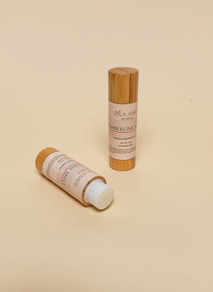 2 bamboo lip balm containers on a beige background