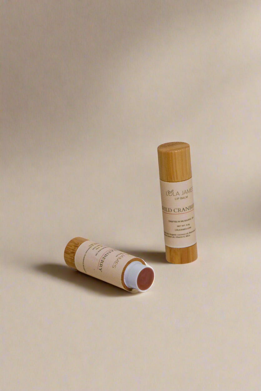 Two bamboo lip balm sticks on a beige background